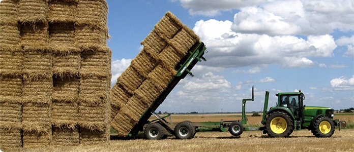 Tractor stacking haybales